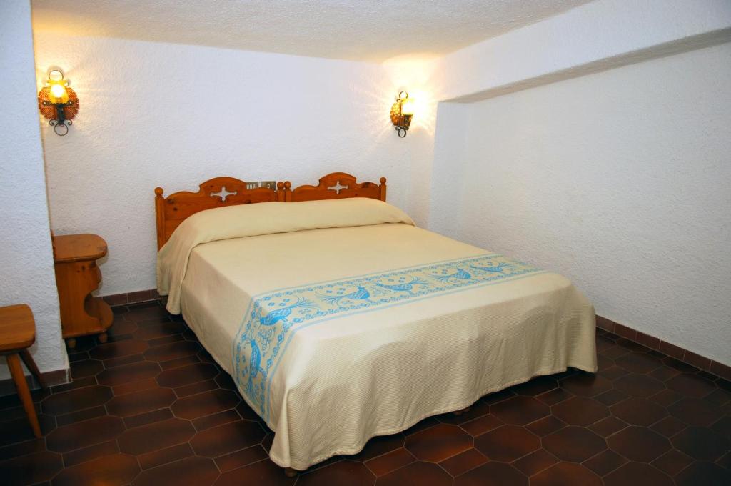 a bedroom with a large bed in a room at HOTEL al FARO ,SPIAGGIA LA CINTA ,SAN TEODORO in San Teodoro