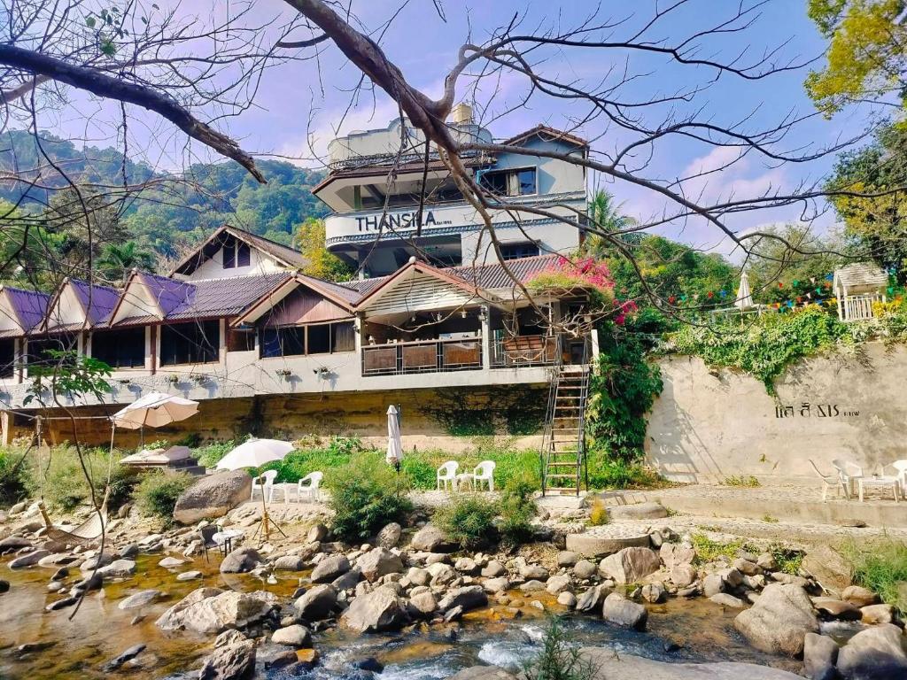 una casa en una colina junto a un río en THANSILA Resort, en Ranong