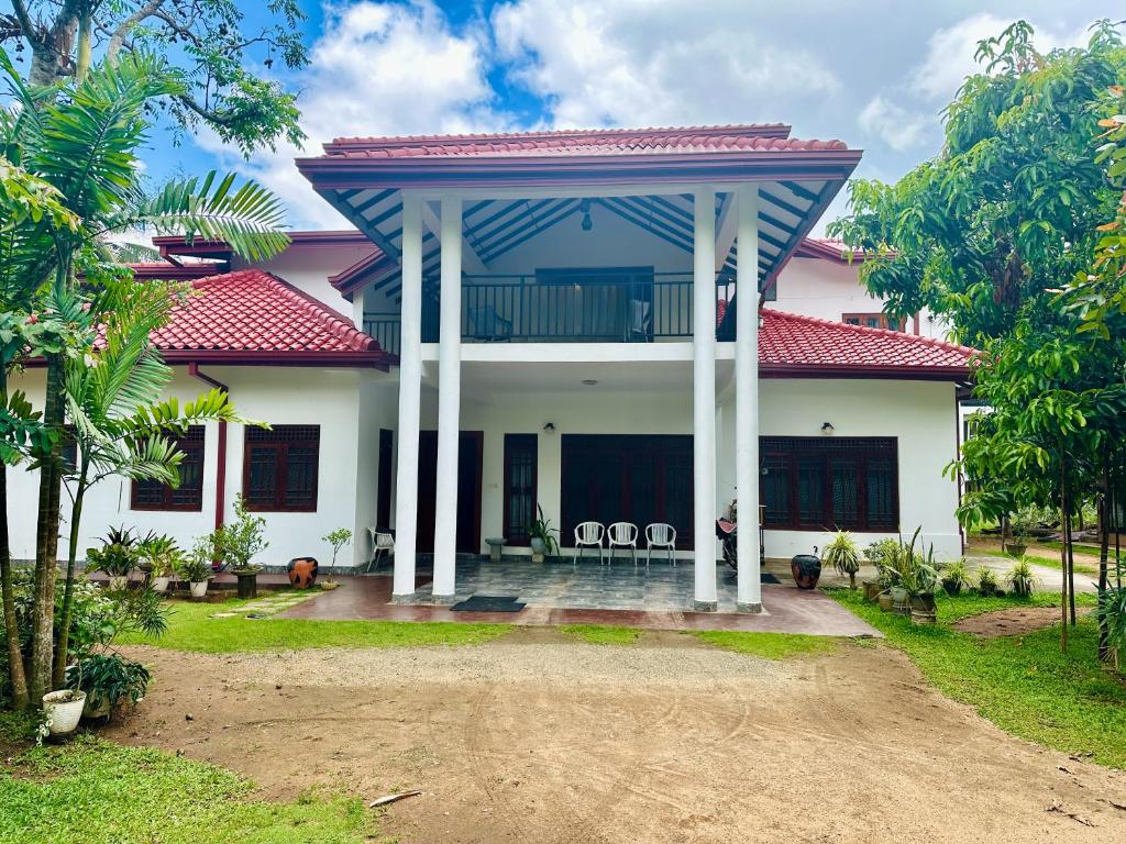 Biały dom z czerwonym dachem w obiekcie Pharo Residence w mieście Anuradhapura