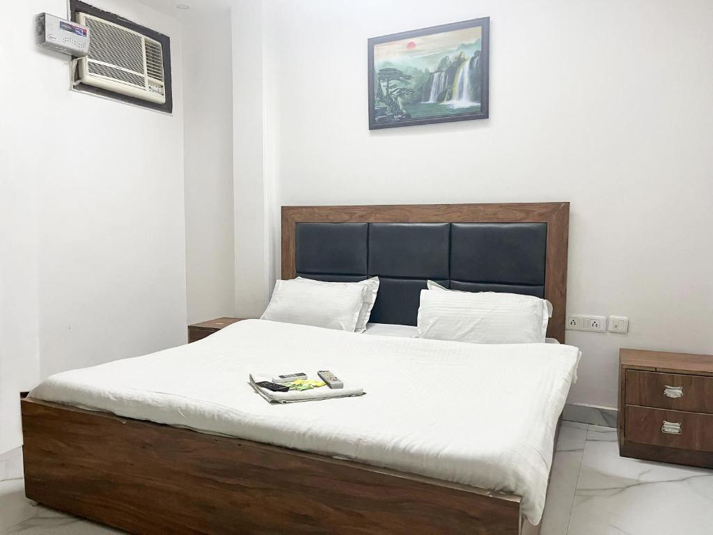 a bedroom with a large bed with white sheets at Hotel Green Residency Near India Gate in New Delhi