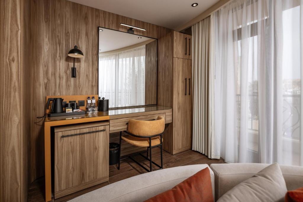 a room with a vanity with a mirror and a chair at Vivaldi Hotel in St. Julianʼs