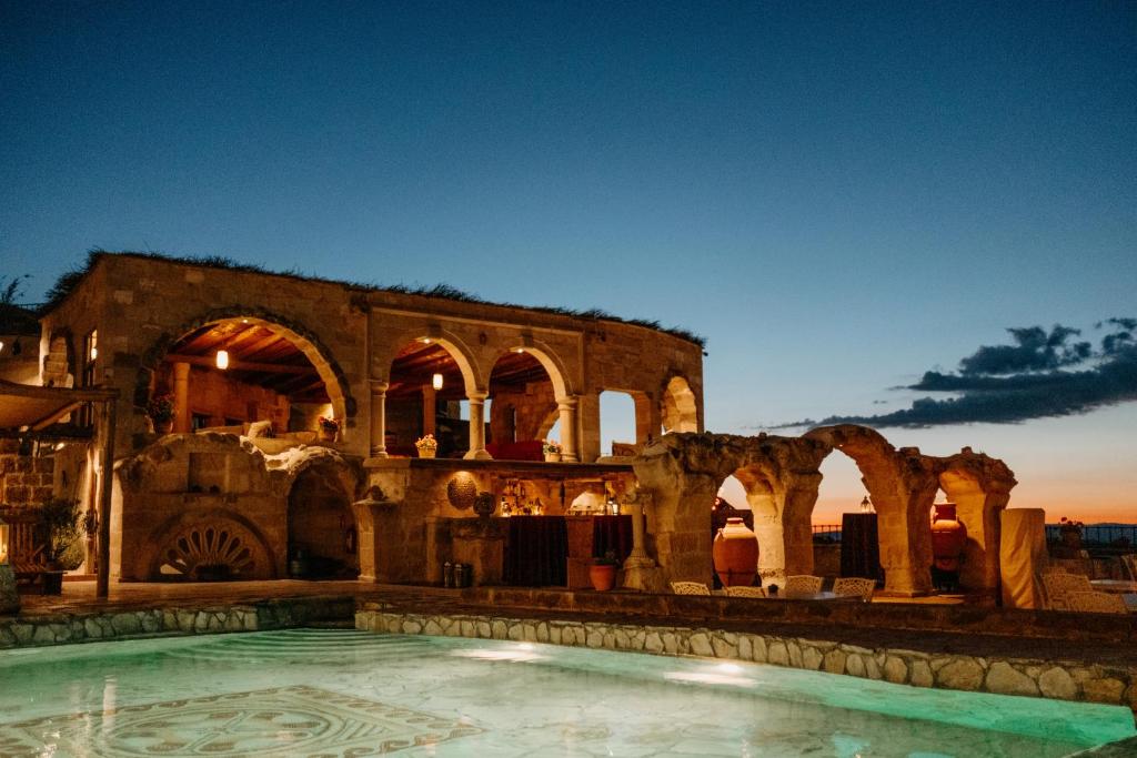 an old building with a swimming pool at night at Museum Hotel in Uçhisar