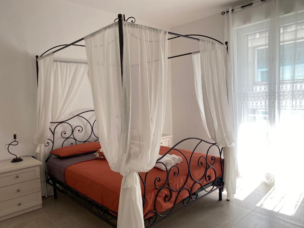 um quarto com uma cama de dossel e cortinas brancas em KATY CHARME Apartment SELF CHECK-IN em Pisa
