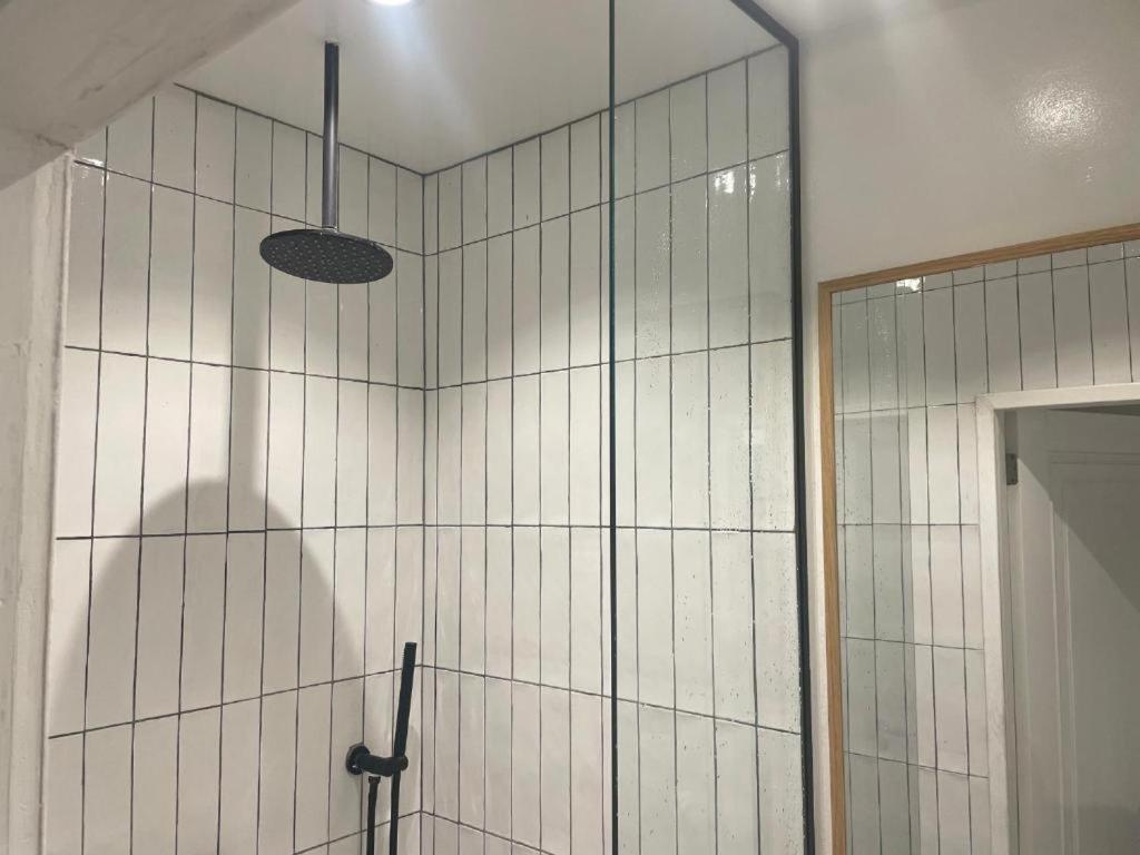 a bathroom with a shower with a glass wall at Hotel Hoofd & Vondel in Amsterdam