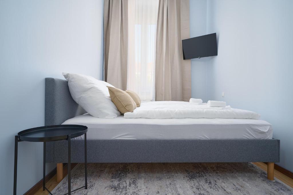 1 dormitorio con 1 cama y TV en la pared en Elys Aparthotel in Leipzig - Vollausgestattete Apartments mit Netflix, en Leipzig