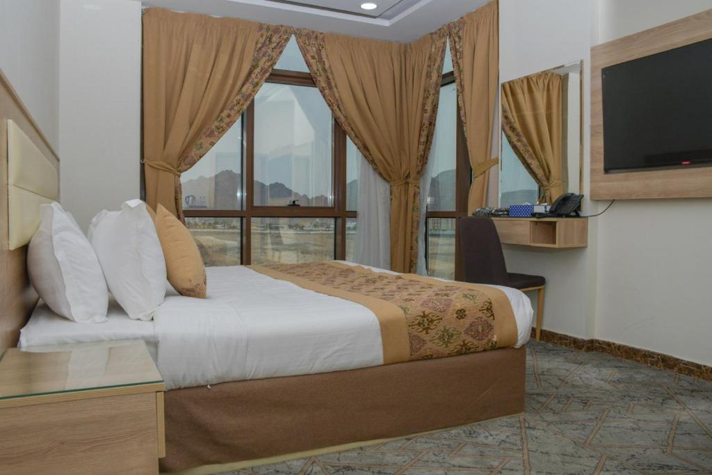 Habitación de hotel con cama y ventana grande en فندق ريست ان en Qabāʼ