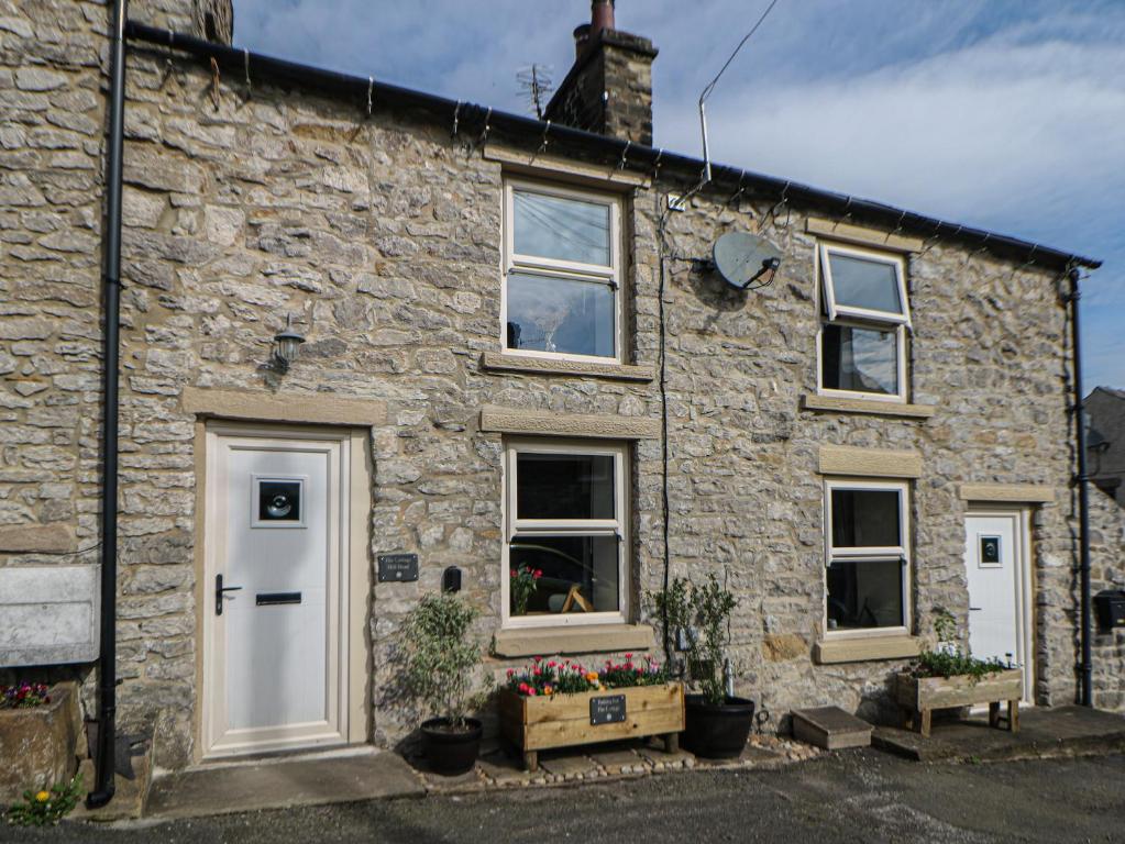 a stone house with white doors and windows at The Cottage Bradwell in Bradwell