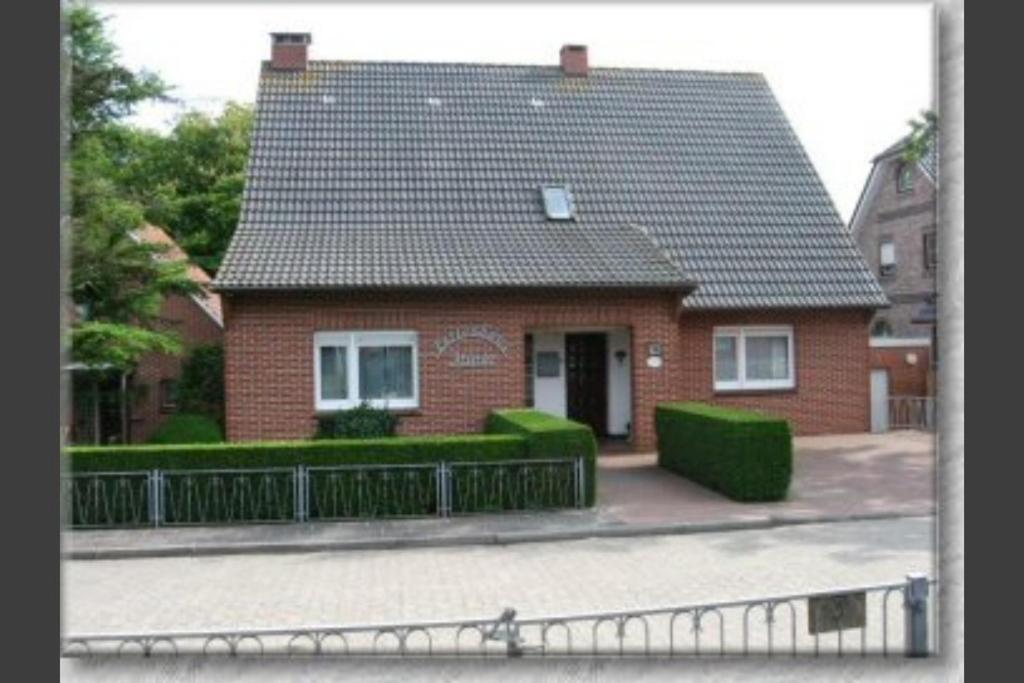 een rood bakstenen huis met een zwart dak bij Haus Minor in Borkum