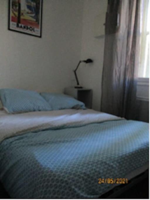 une chambre avec un lit avec des oreillers bleus et une fenêtre dans l'établissement Bandol - City Center - Small One Bedroom Flat, à Bandol