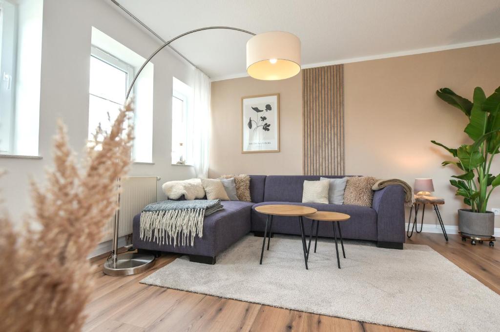 a living room with a blue couch and a table at Eigene Sauna 2 Schlafzimmer sehr zentral WinterbergHome in Winterberg