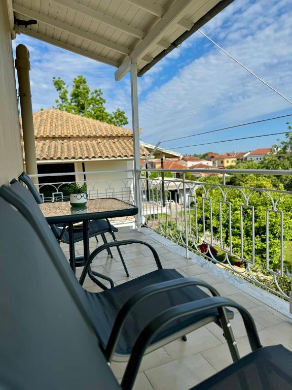 a patio with a table and chairs on a balcony at Captain Christos Family Garden House in Lefkimmi