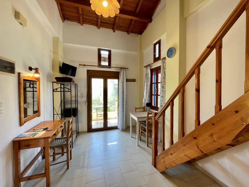 ein Wohnzimmer mit einem Holztisch und einer Treppe in der Unterkunft Jimmy's Place in Órmos Marathokámpou