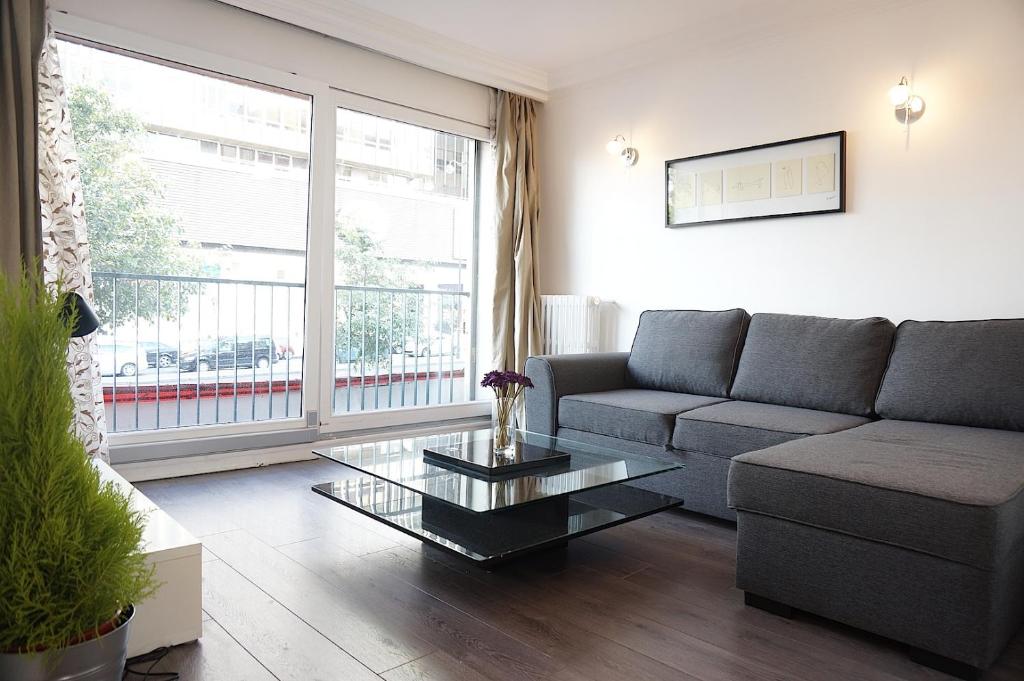 un salon avec un canapé et une table basse dans l'établissement Montparnasse 1BDR, à Paris