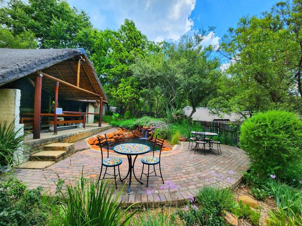 a patio with a table and chairs and a fire pit at Pine Valley in Lanseria