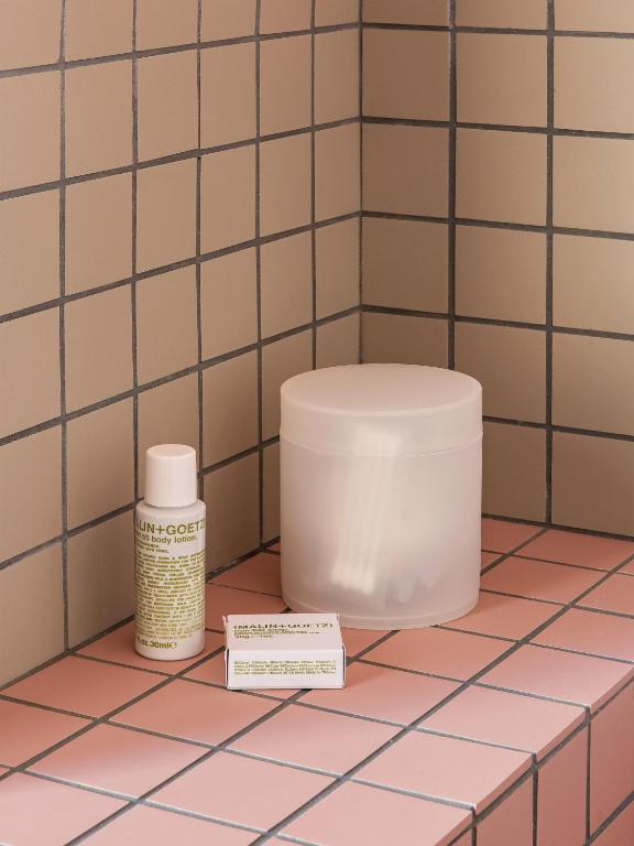 a bathroom with a toilet and a bottle of cosmetics at New Hotel Opéra in Paris