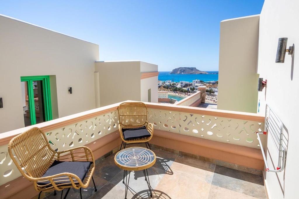 two chairs on a balcony with a view of the ocean at La Scala Luxury Villa Μikis Theodorakis with jacuzzi in Karpathos