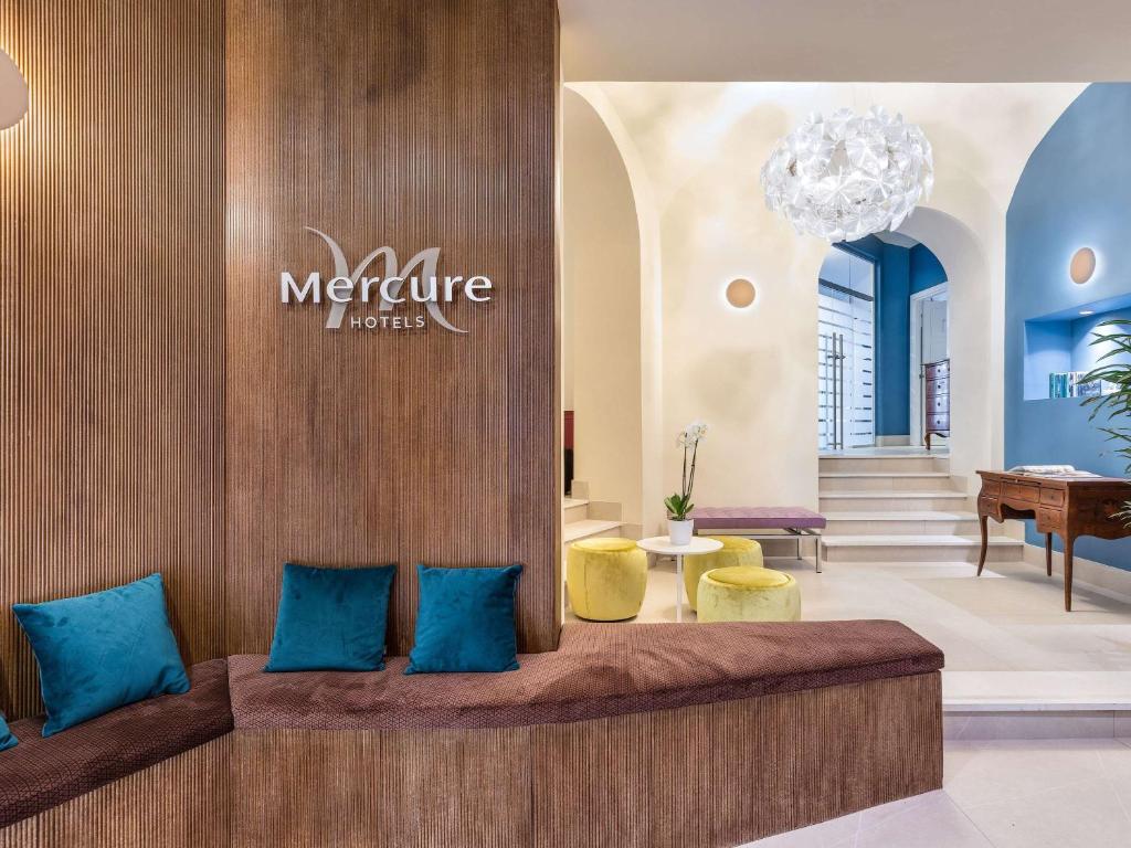 un vestíbulo de un hotel marriott con almohadas azules en Mercure Napoli Centro Angioino, en Nápoles