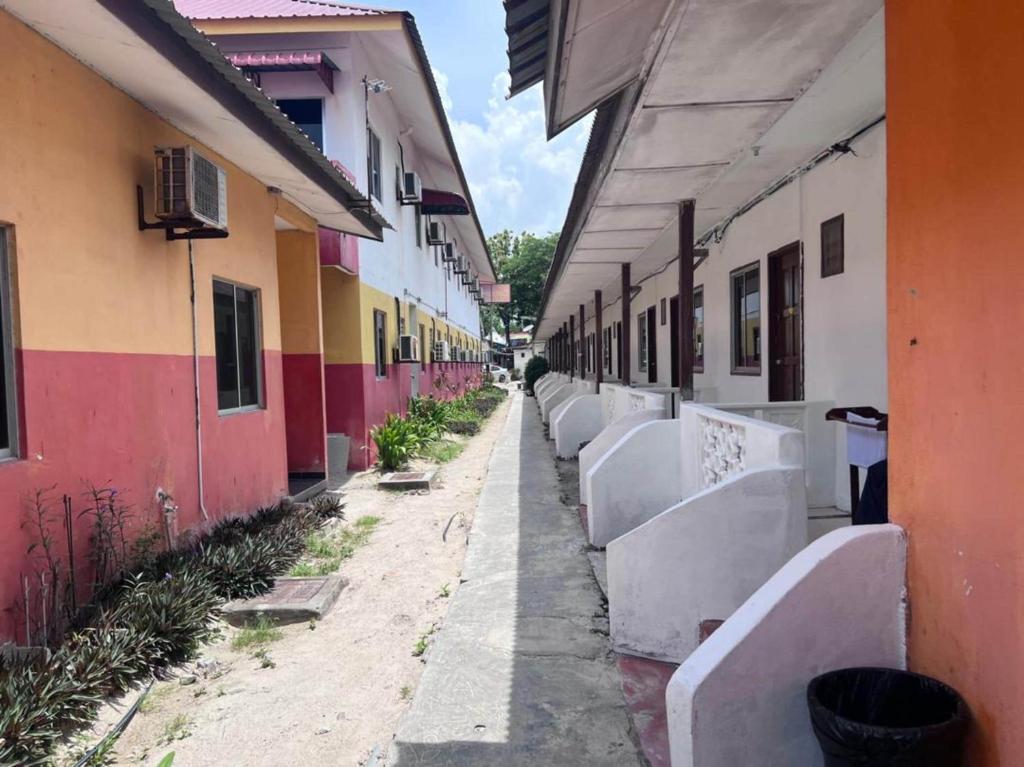 a row of benches in an alley between buildings at OYO 90981 Chenang Rest House 1 in Pantai Cenang