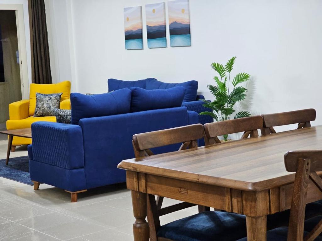 een woonkamer met een blauwe bank en een tafel bij Coronado North Coast Chalet Sea view for Families Only in El Dab‘a