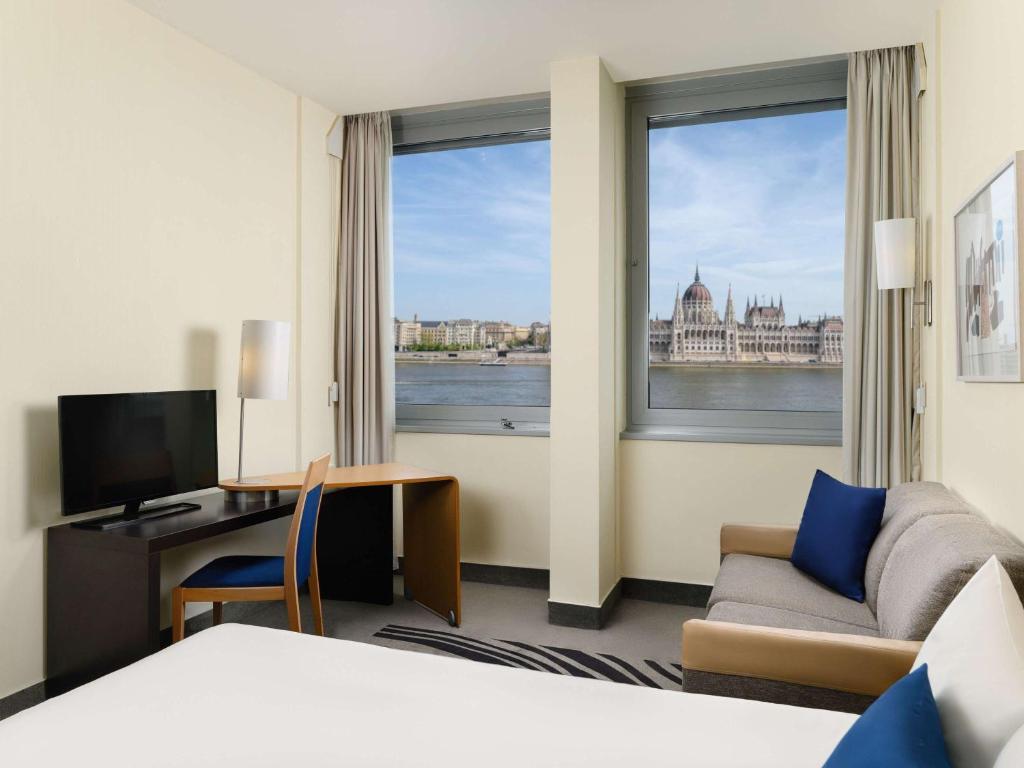 una camera d'albergo con vista sull'acqua di Novotel Budapest Danube a Budapest