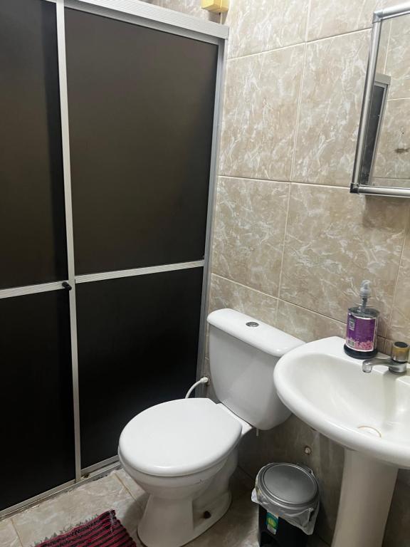 a bathroom with a toilet and a sink at Casa Caruaru in Caruaru