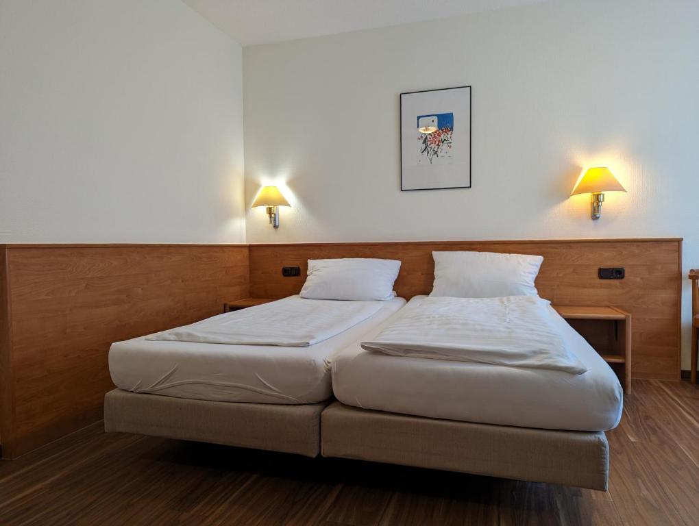 a bedroom with two beds and two lights on the wall at Sonnenhof in Katlenburg-Lindau