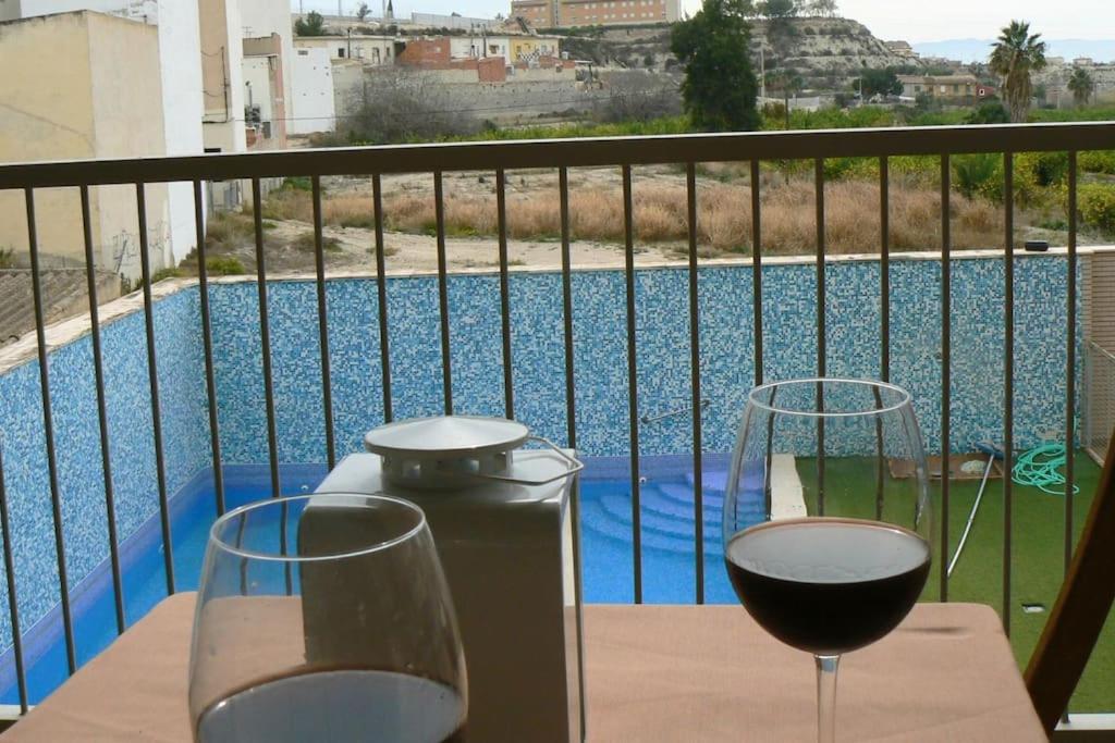 stół z dwoma kieliszkami wina na balkonie w obiekcie Apartamento en centro de Archena w Murcji