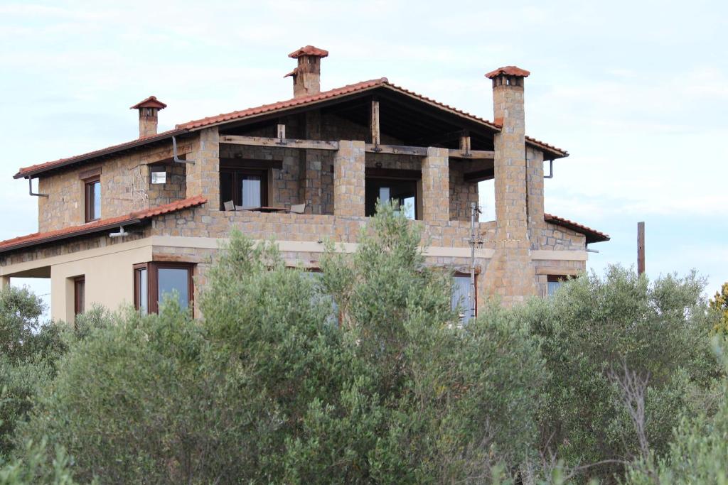 ein Backsteinhaus mit drei Schornsteinen auf Bäumen in der Unterkunft Country House in Paralia Dionisiou
