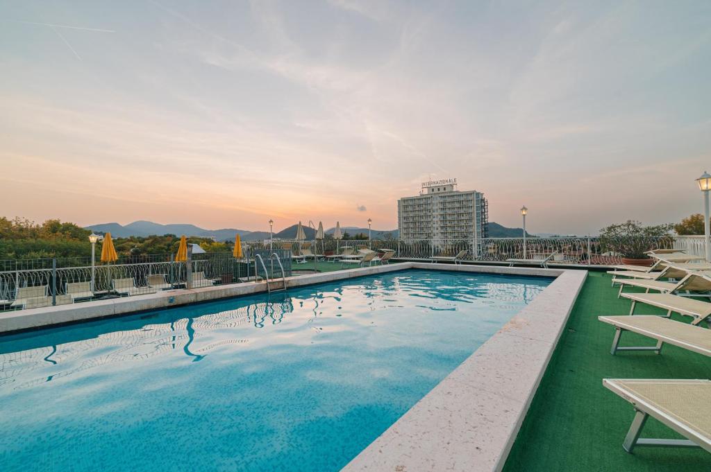 阿巴諾泰爾梅的住宿－羅馬提米酒店，一座带椅子的大型游泳池和一座建筑