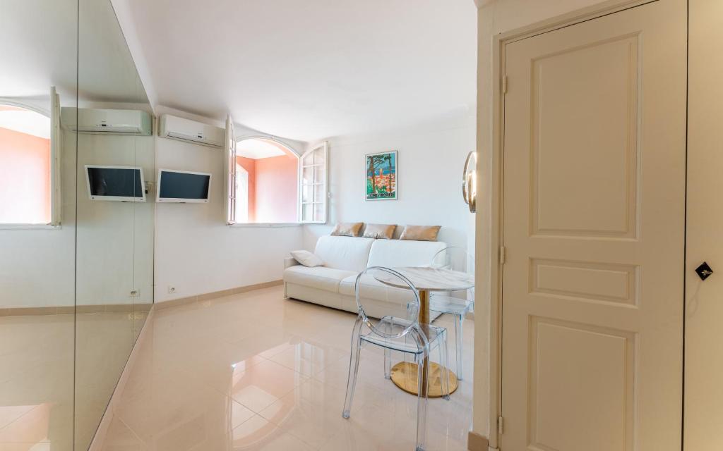 un salon blanc avec un canapé blanc et une table dans l'établissement Saint Tropez, coeur de village, appartement unique, à Saint-Tropez