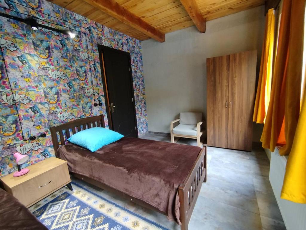 1 dormitorio con 1 cama y una pared colorida en BikePost AIR Georgia, en Zeda Dagva