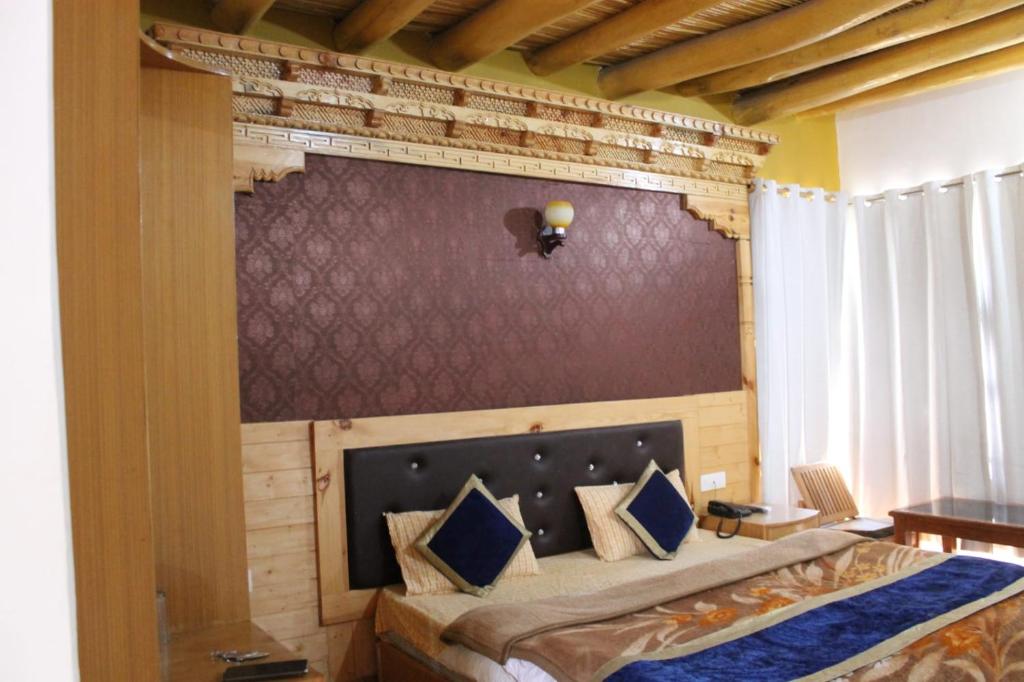 1 dormitorio con 1 cama grande y pared en Hotel Royal Plaza, en Leh