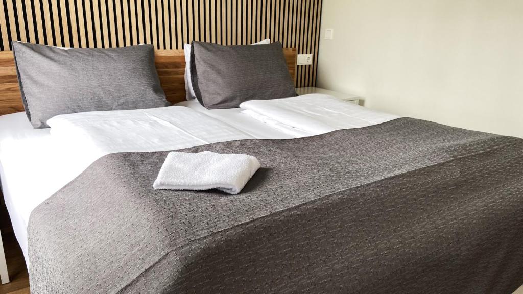 un letto con due cuscini e un asciugamano sopra di Skipalaekur Guesthouse a Egilsstadir