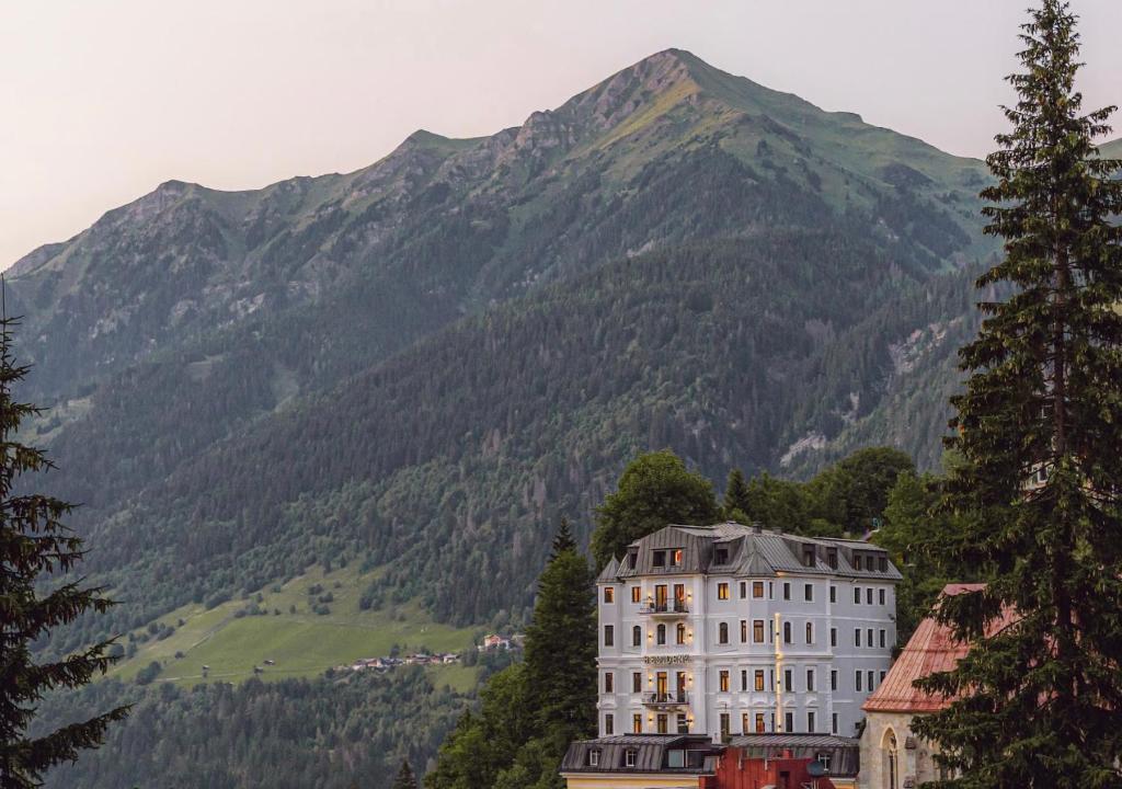 a large white building in front of a mountain at Residenz Boutique Suites in Bad Gastein