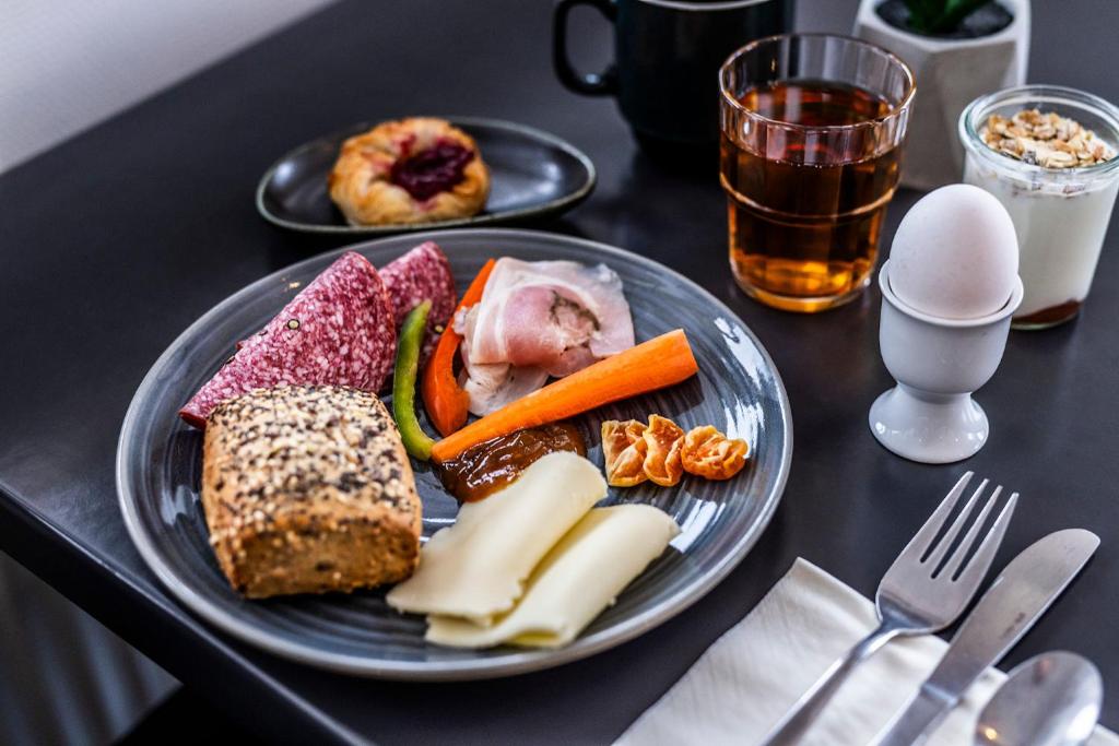 a plate of food with meat and vegetables on a table at HOTEL SØMA Ilulissat in Ilulissat