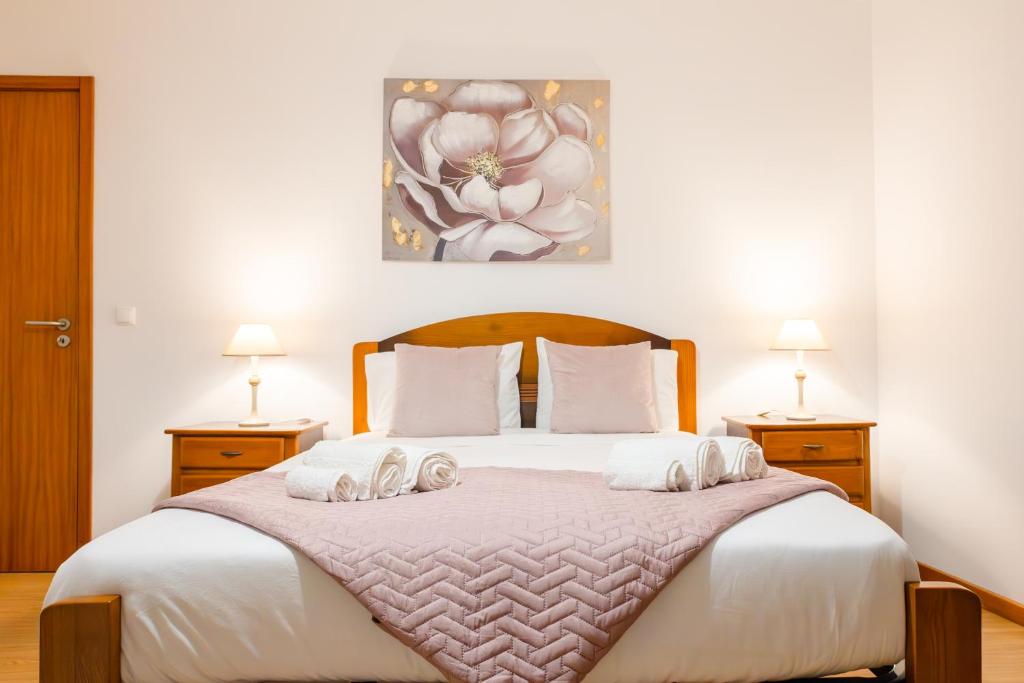 Un dormitorio con una cama grande con dos mesitas de noche. en Maria Benta House, en Ribeira Grande