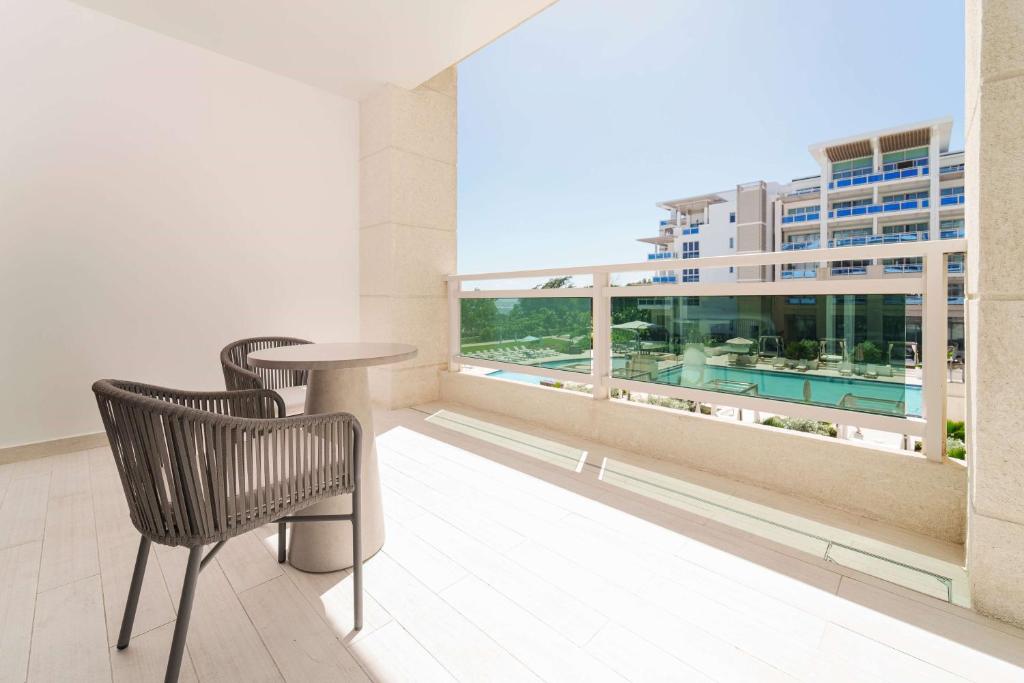 a balcony with a table and chair on a building at Wyndham Grand Barbados Sam Lords Castle All Inclusive Resort in Saint Philip