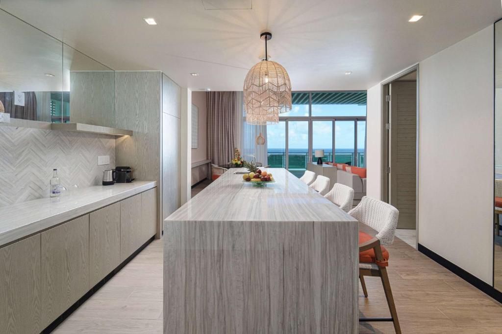 a kitchen and dining room with a large island in the middle at Wyndham Grand Barbados Sam Lords Castle All Inclusive Resort in Saint Philip