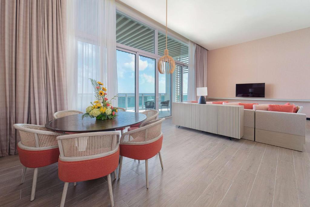 a living room with a table and chairs and a couch at Wyndham Grand Barbados Sam Lords Castle All Inclusive Resort in Saint Philip