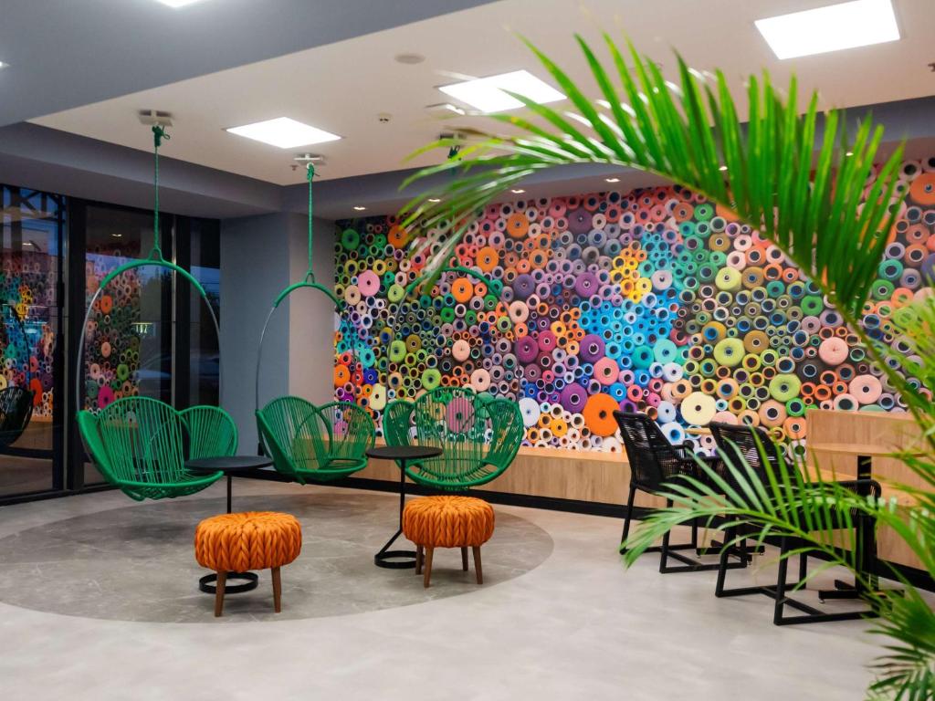 a wall mural in a restaurant with chairs and a table at ibis Styles Goiânia Shopping Estação in Goiânia