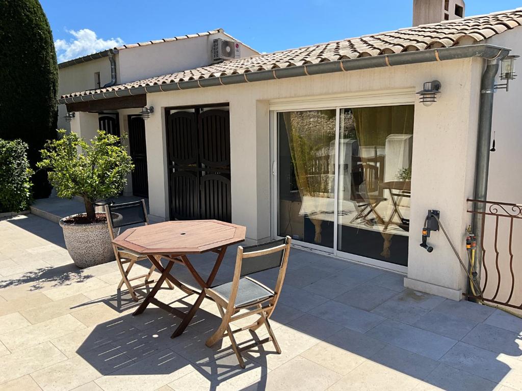 une table et des chaises en bois sur une terrasse dans l'établissement Studio indépendant cosy, à Fréjus