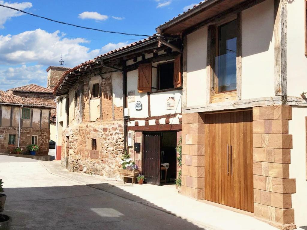 un edificio antiguo con una puerta de madera en una calle en 4 bedrooms house with lake view garden and wifi at Villasur de Herreros, en Villasur de Herreros