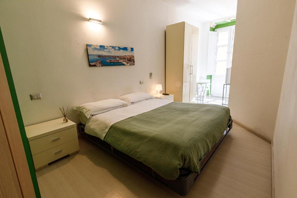 1 dormitorio con cama, mesa y ventana en Onlyrooms II - Old Town & Typical Food, en Cagliari