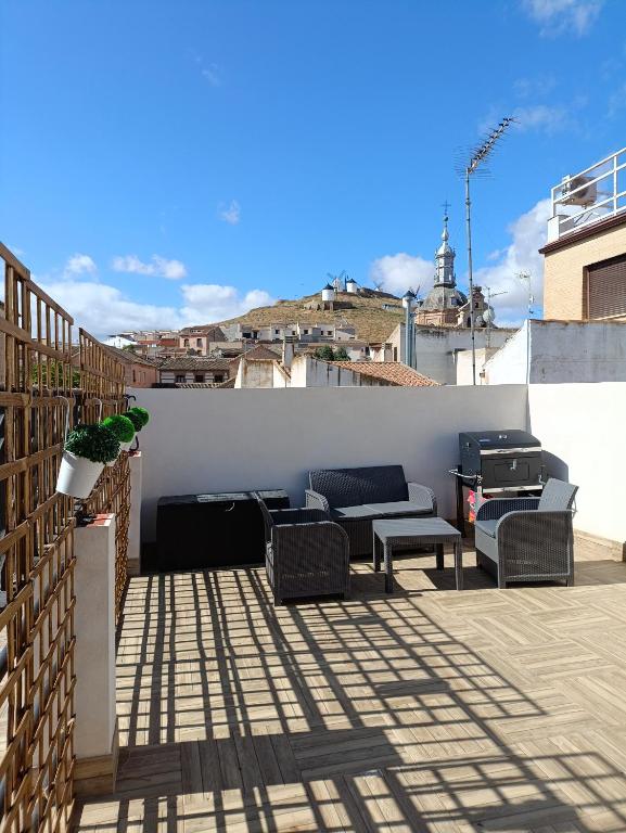 a patio with couches and chairs on a roof at Casa Encanto Consuegra in Consuegra