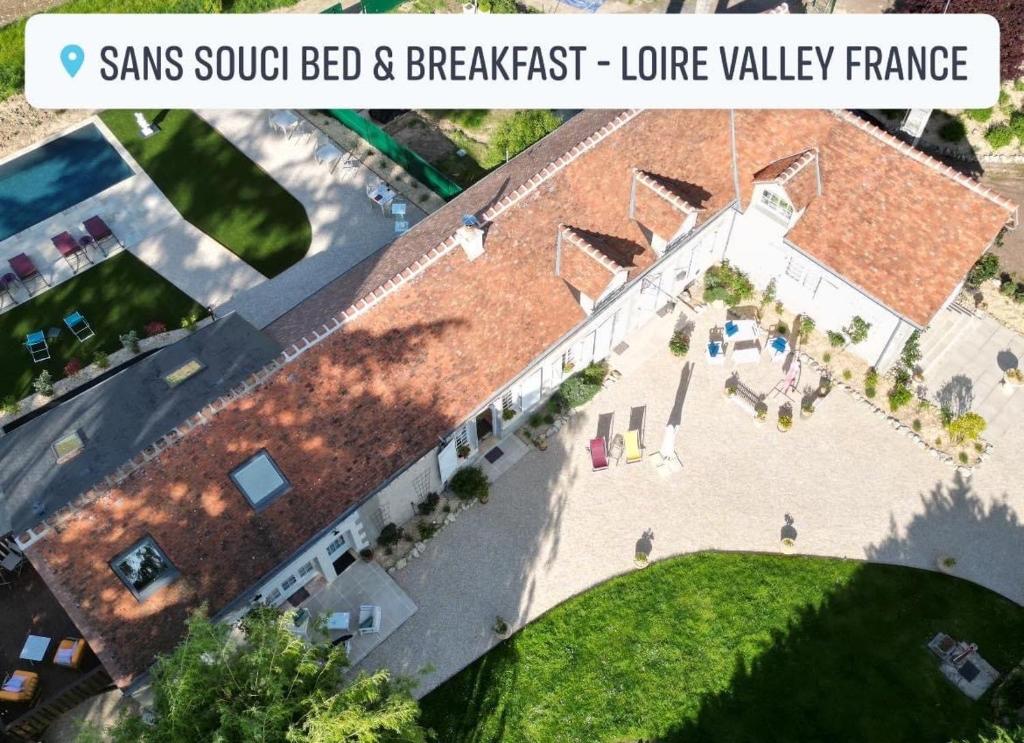 einen Blick über ein großes Backsteingebäude in der Unterkunft Sans Souci Bed and Breakfast Luxe Heated Pool and Restaurant in Luzillé