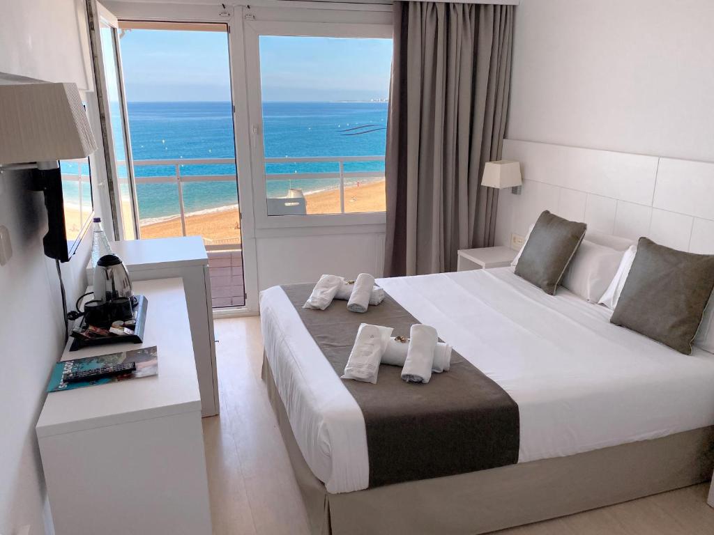 a bedroom with a bed with a view of the ocean at Hotel Rosamar Maxim 4*- Adults Only in Lloret de Mar
