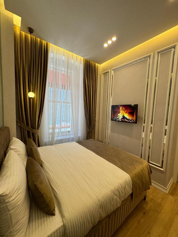 Un dormitorio con una cama grande y una ventana en The Aramis Galata Hotel, en Estambul