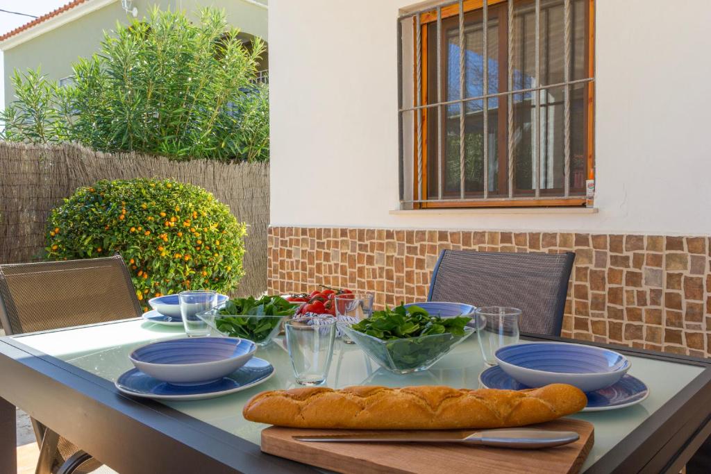 a table with plates and bowls of food on it at Chalet OLIVA NOVA in Oliva