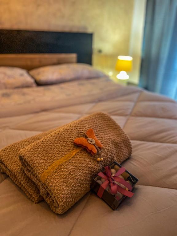 Una cama con una toalla y un regalo. en Guest House Isabel Pinto, en Santa Maria di Sala