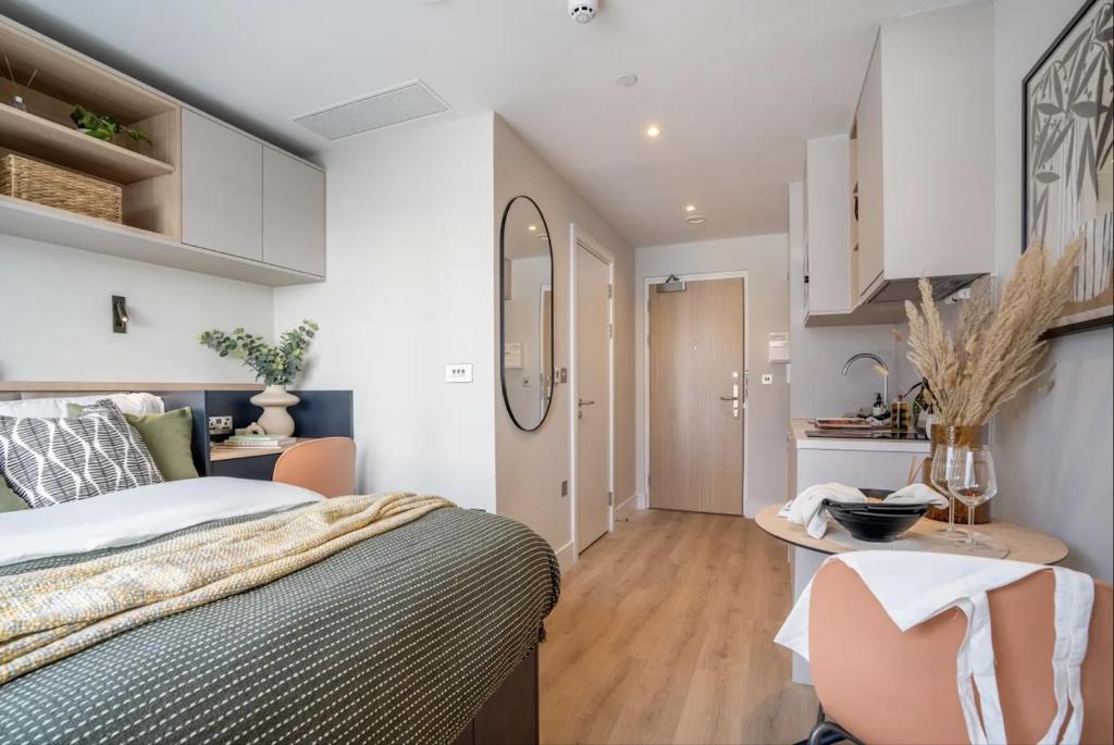 ein Schlafzimmer mit einem Bett und einem Schreibtisch sowie eine Küche in der Unterkunft En-suite room in London
